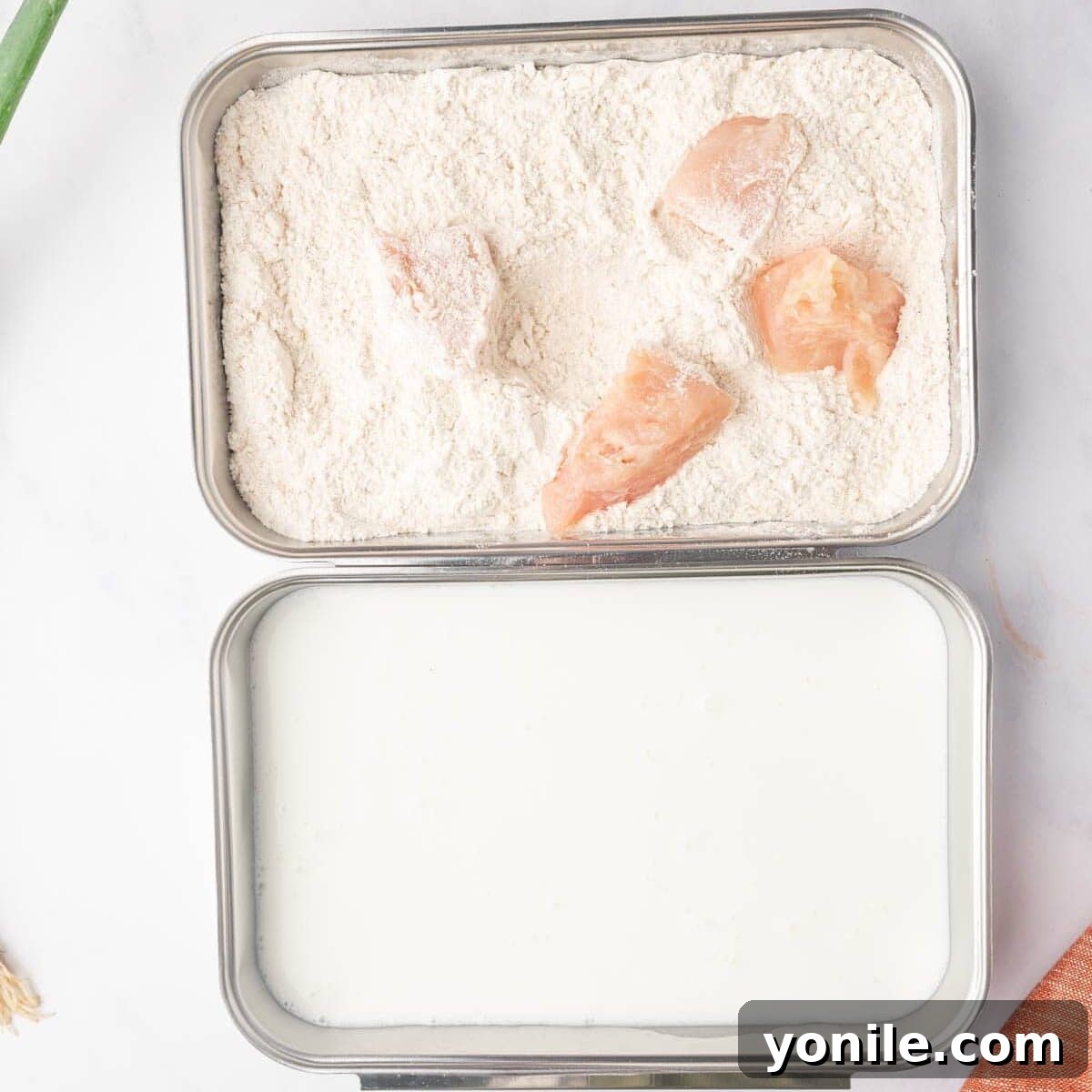 Process of dredging the chicken in buttermilk and flour mixtures.
