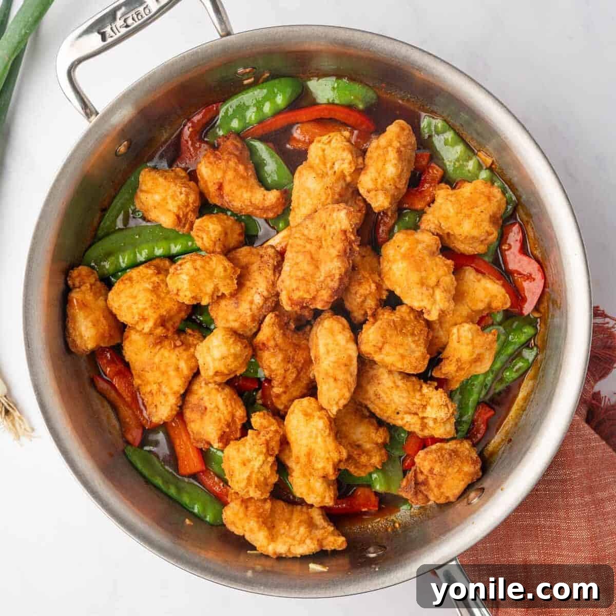 Fried chicken is added to the sauteed veggies.