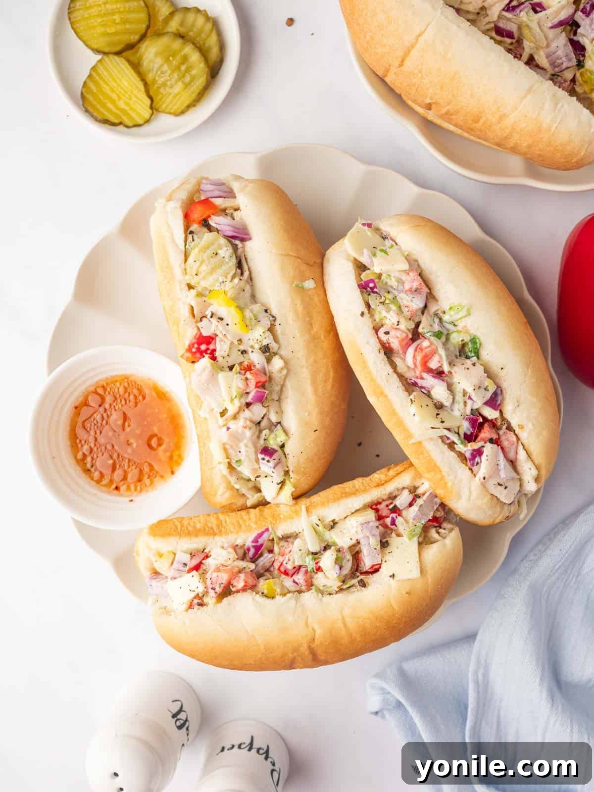 Zesty Chopped Italian Hero 2 Sub rolls on a tray filled with chopped deli meat and vegetables, ready to be served.