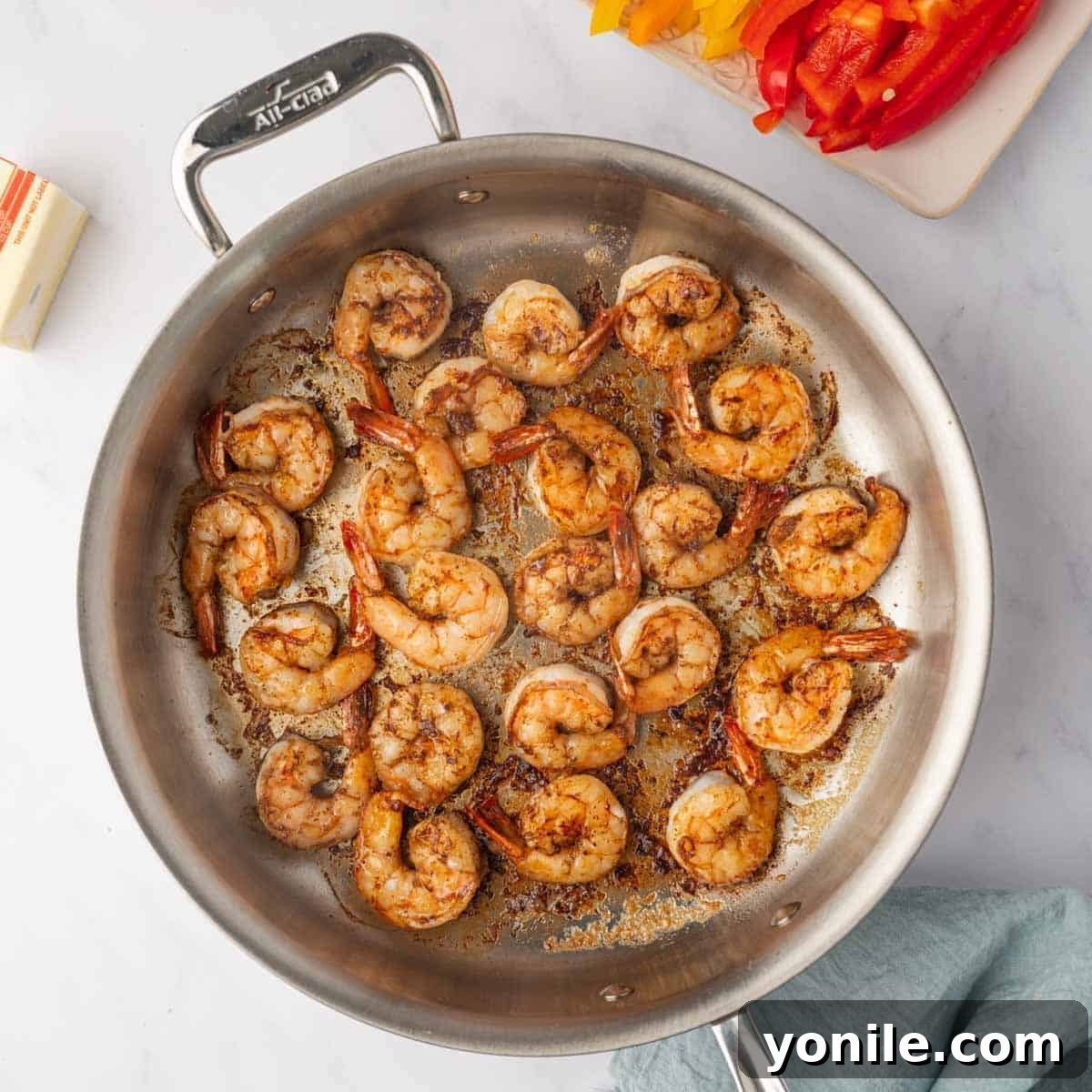 Succulent jerk-seasoned shrimp being expertly cooked in a hot skillet until perfectly pink and tender.