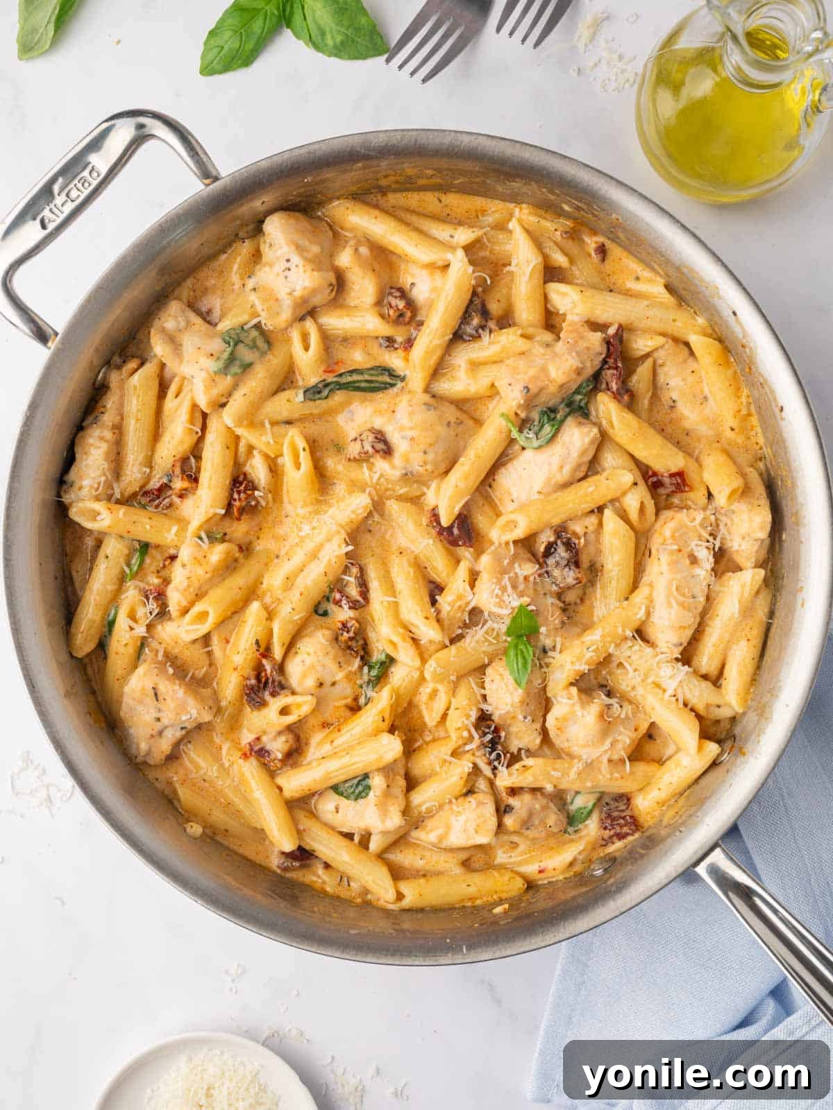 Proposal Chicken Pasta 2 Marry me chicken pasta in a skillet, showcasing a generous portion of creamy pasta with chicken and sun-dried tomatoes.