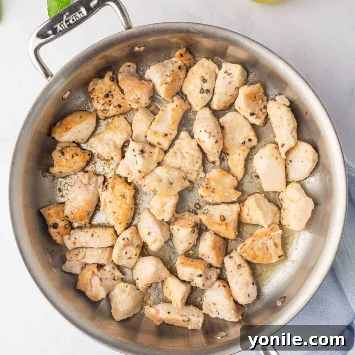 Proposal Chicken Pasta 5 Golden-brown chicken pieces sizzling in a large skillet, indicating they are cooked through.