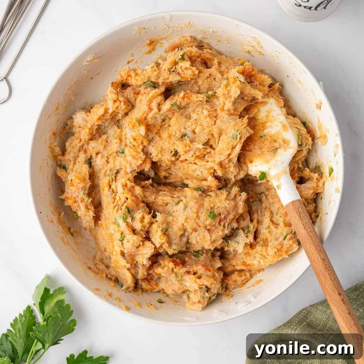 Flavorful Chicken Kofta Skewers 5 A hand mixing the ground chicken, herbs, and spices thoroughly in a bowl, ensuring all components are well incorporated to form a cohesive mixture.