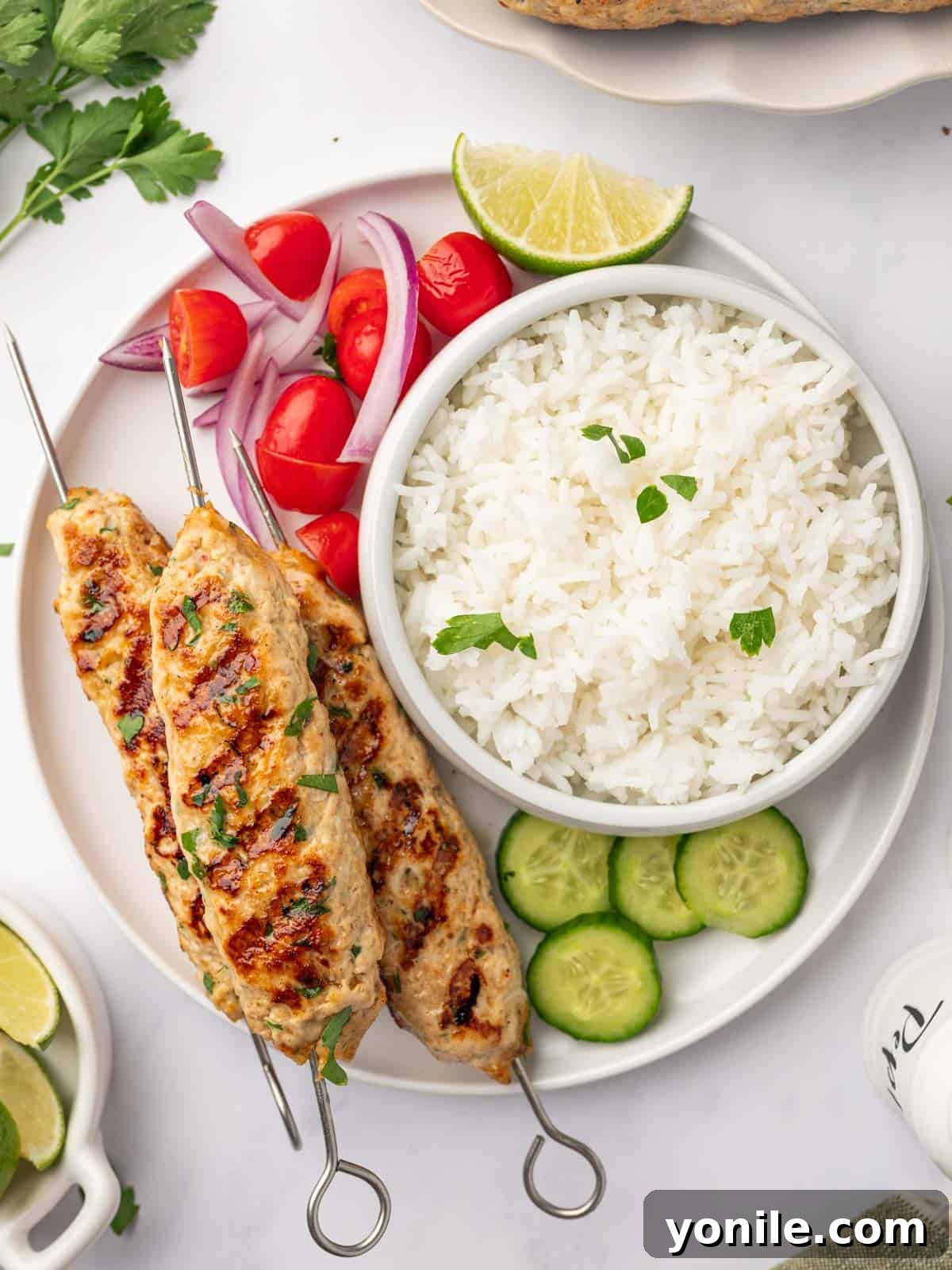 Flavorful Chicken Kofta Skewers 9 A vibrant platter of grilled chicken kofta served alongside fluffy rice and an assortment of colorful roasted vegetables, garnished with fresh herbs.