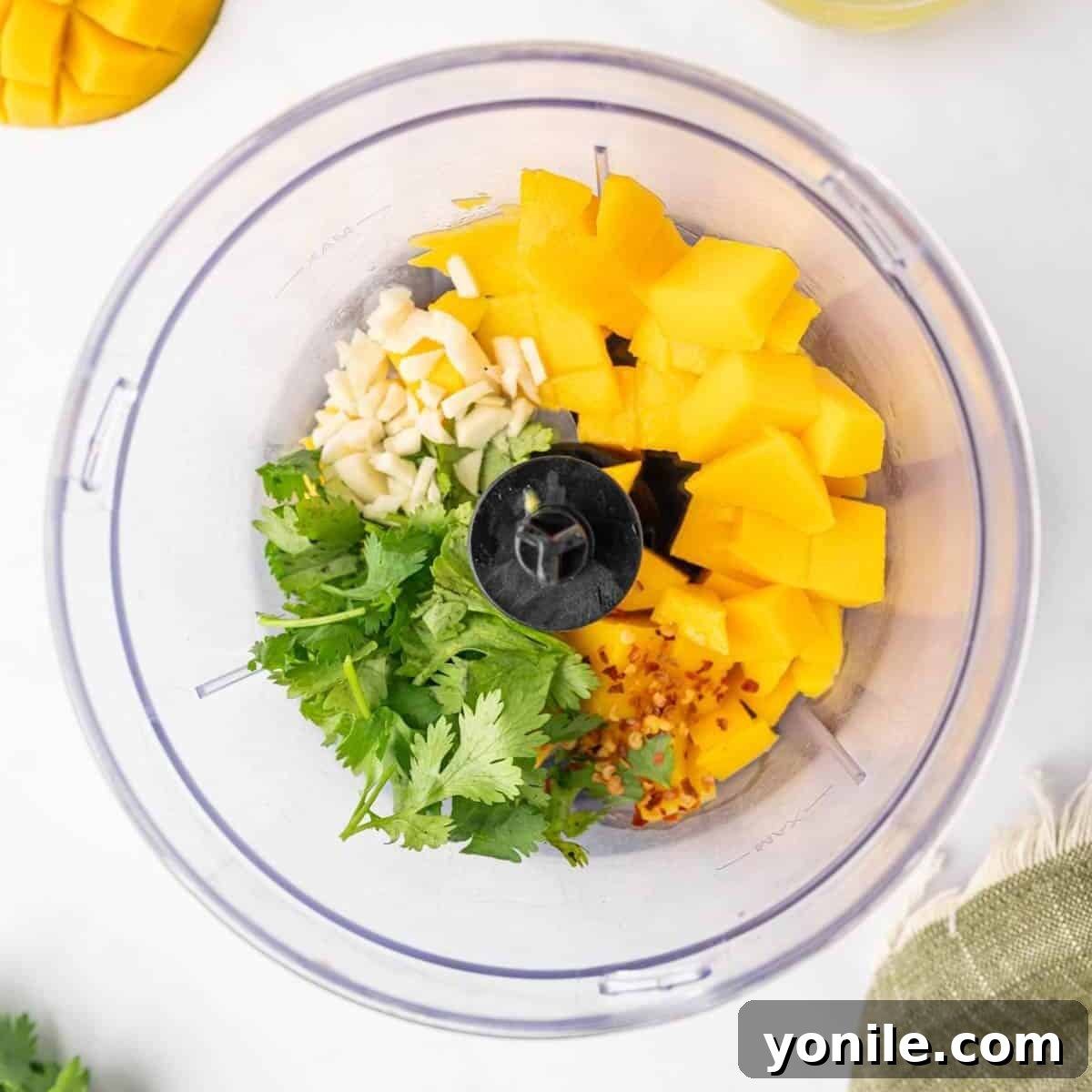 Preparing the mango salad dressing in a food processor, with fresh mango and other dressing ingredients visible.