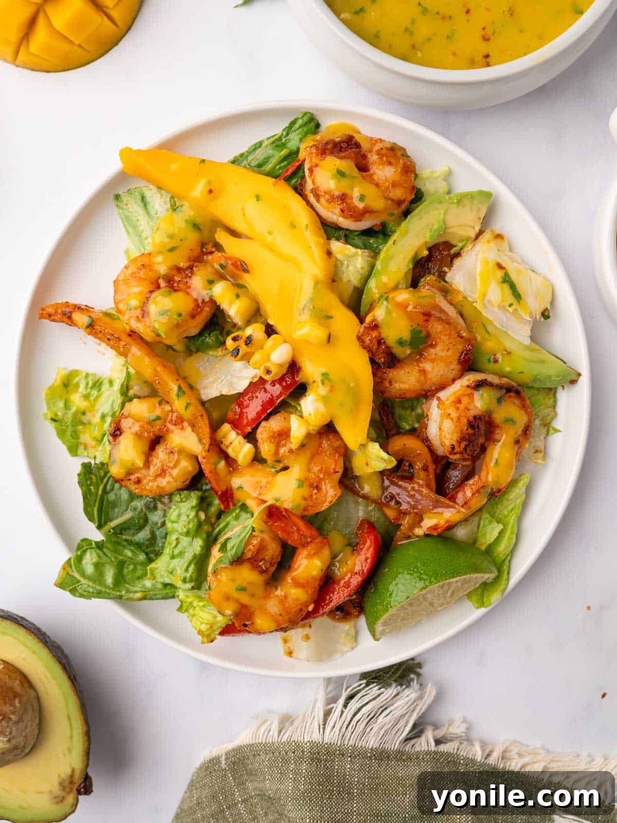 A single serving plate of Mango Shrimp Salad, beautifully arranged with shrimp, mango, and greens.