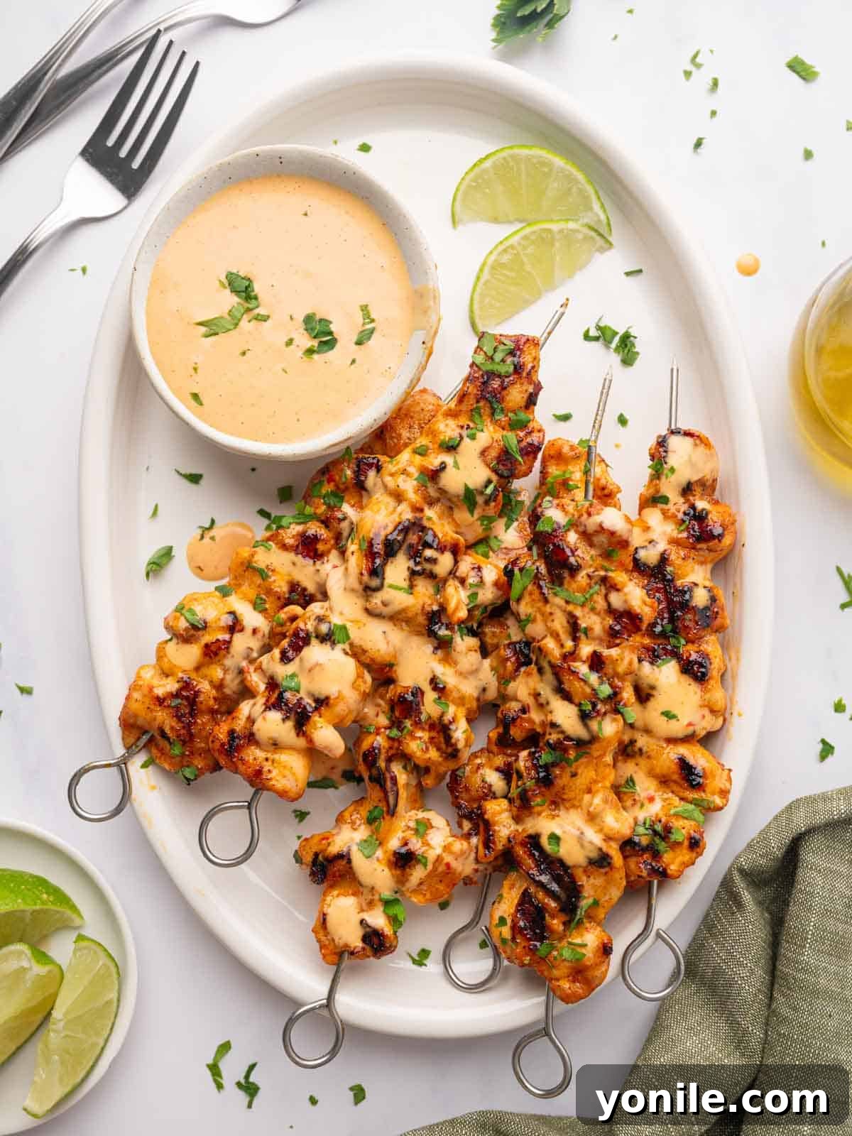 A vibrant platter of Bang Bang Chicken Skewers, garnished and ready to serve.