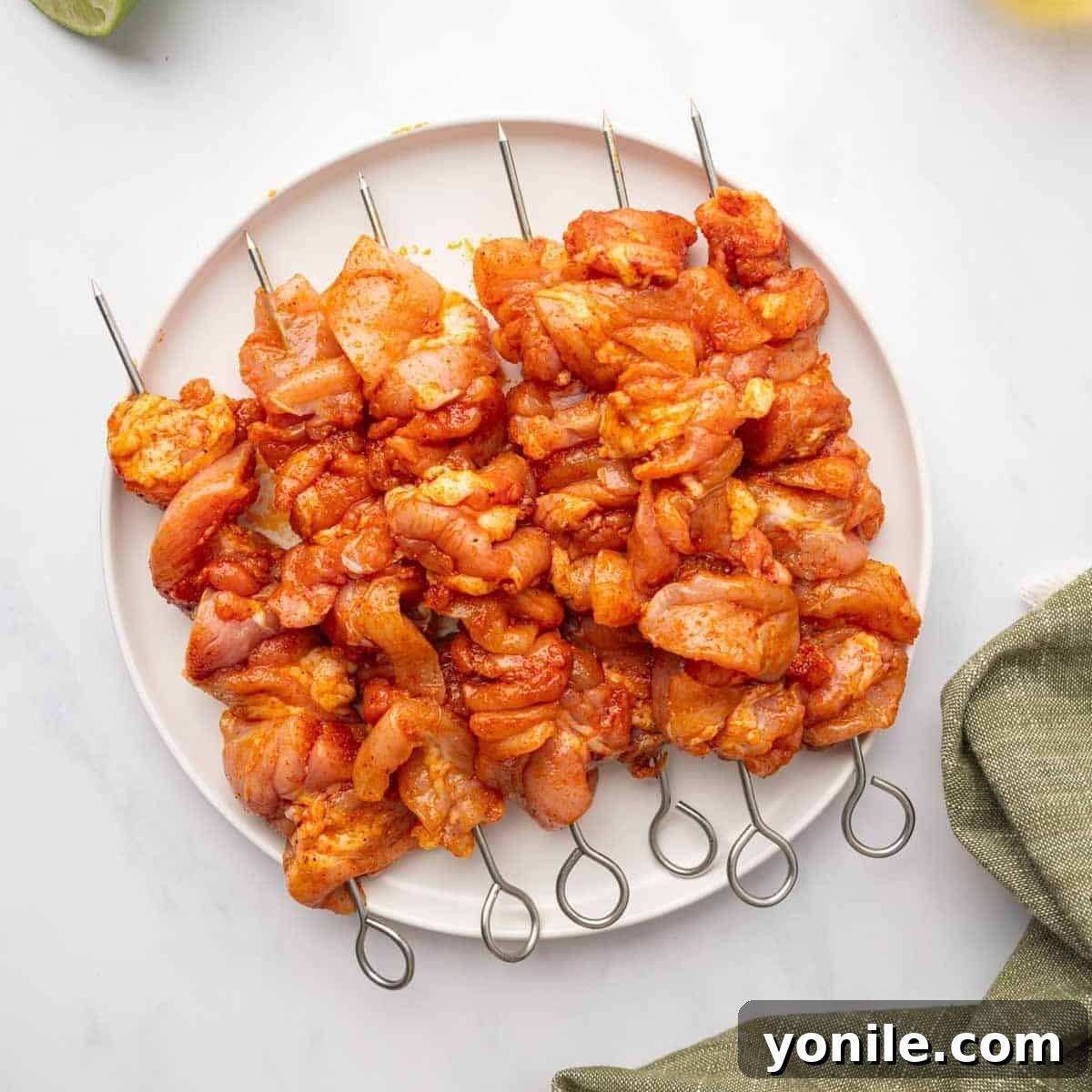 Marinated chicken cubes neatly threaded onto skewers.