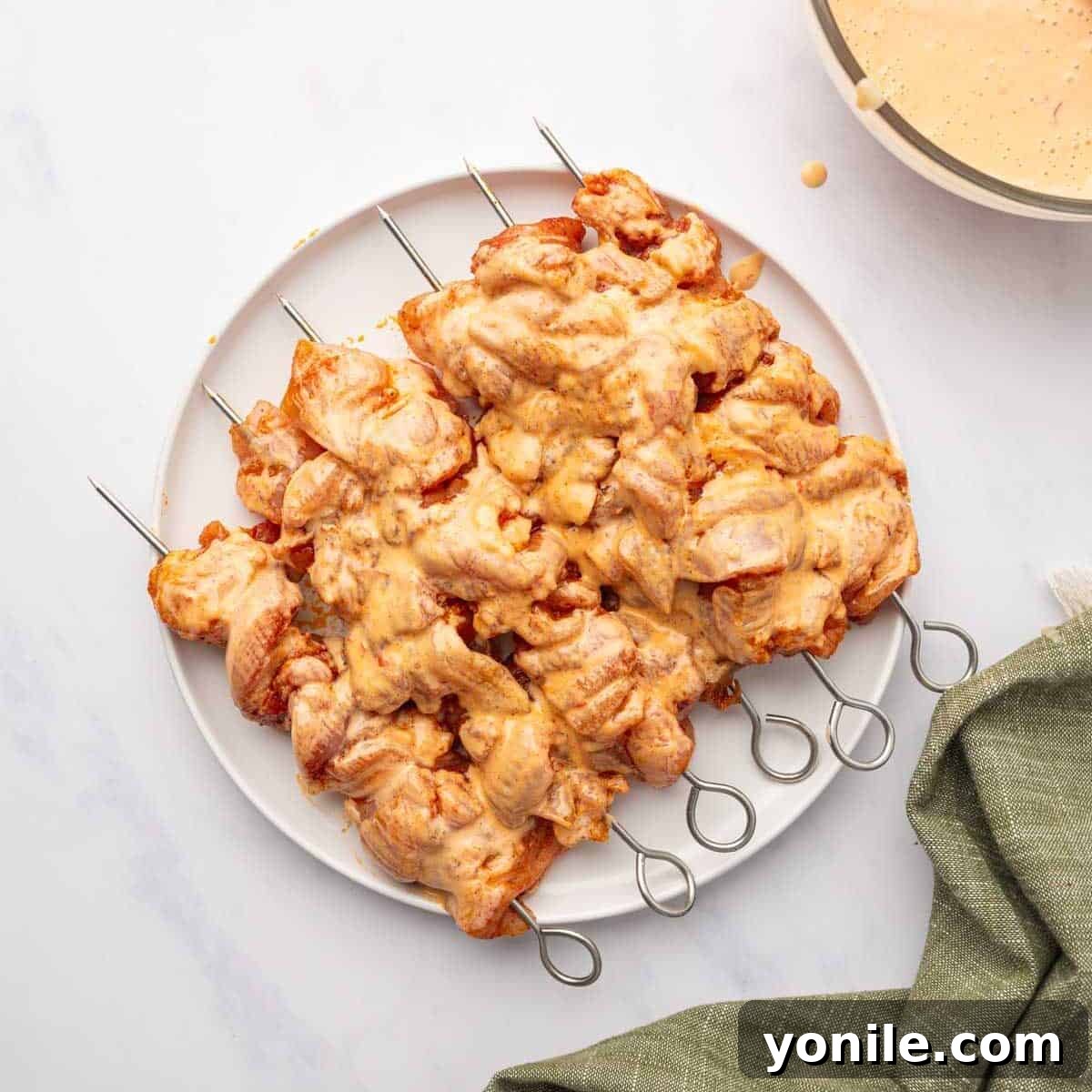 Grilled chicken skewers glistening with a coat of Bang Bang sauce.