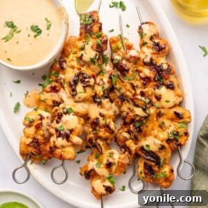 A vibrant platter of Bang Bang Chicken Skewers, garnished and ready to serve.