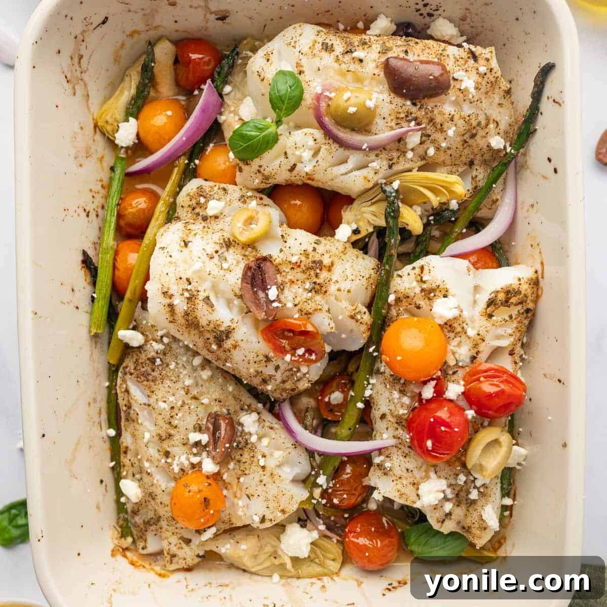 Sun-Kissed Mediterranean Cod 7 Baked Mediterranean cod, garnished with feta and basil, resting in a baking dish.