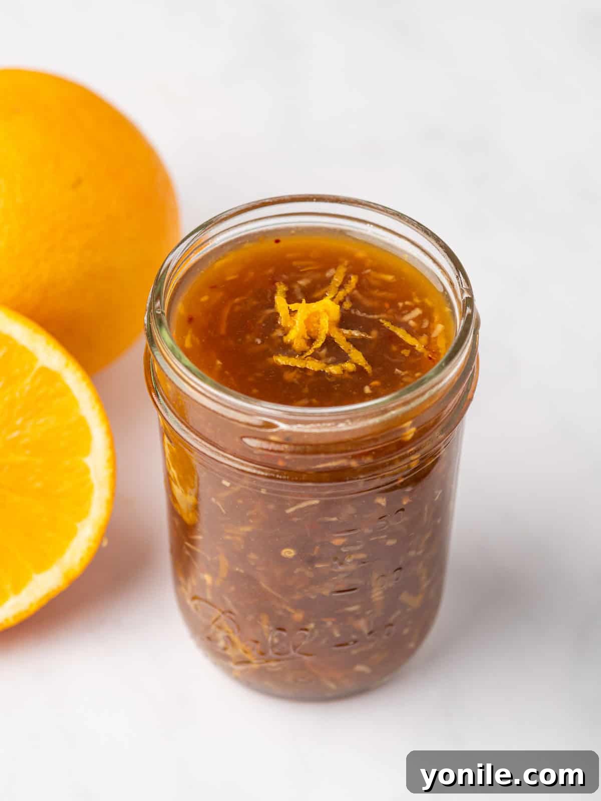 Easy Orange Chicken sauce in a jar, showcasing its vibrant color and smooth texture.