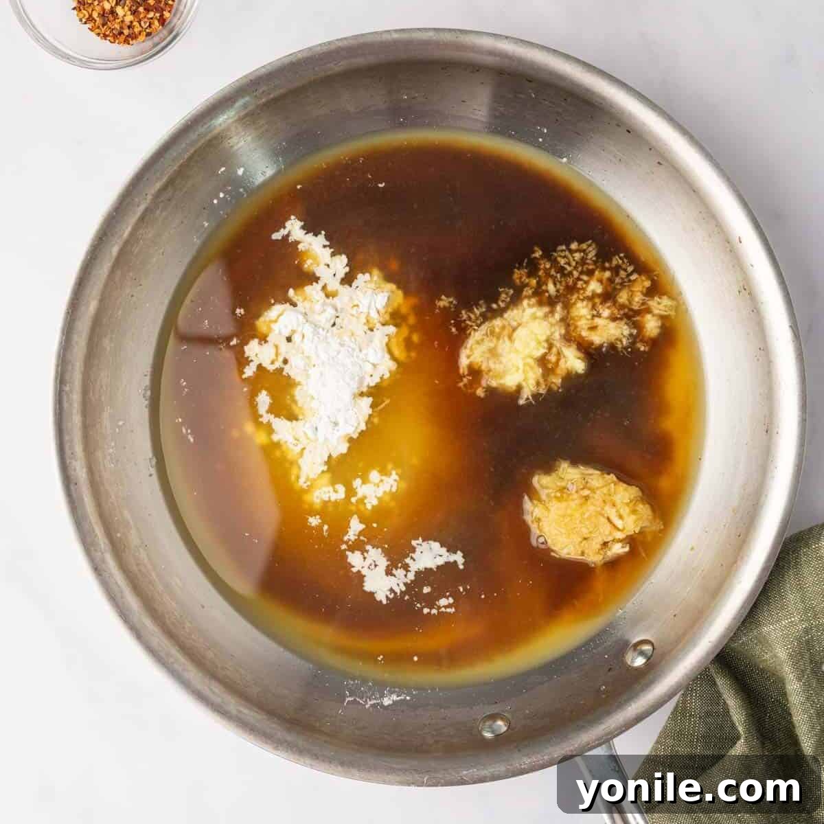 All liquid and dry sauce ingredients are combined in a small skillet, ready to be heated.
