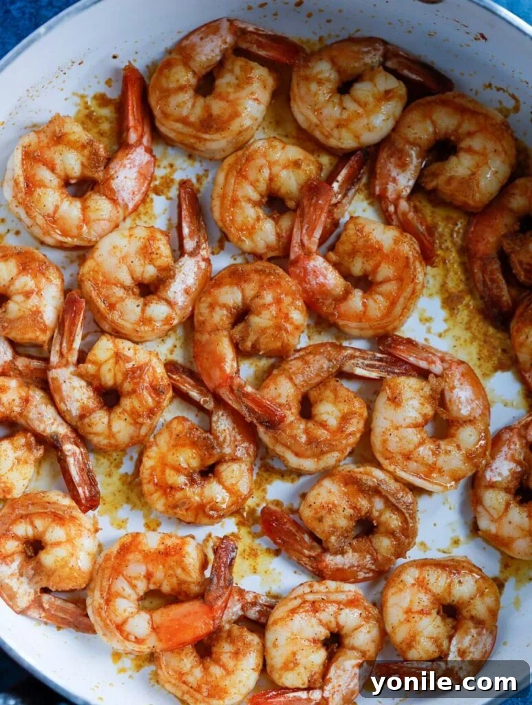 pan seared cajun shrimp in a skillet.