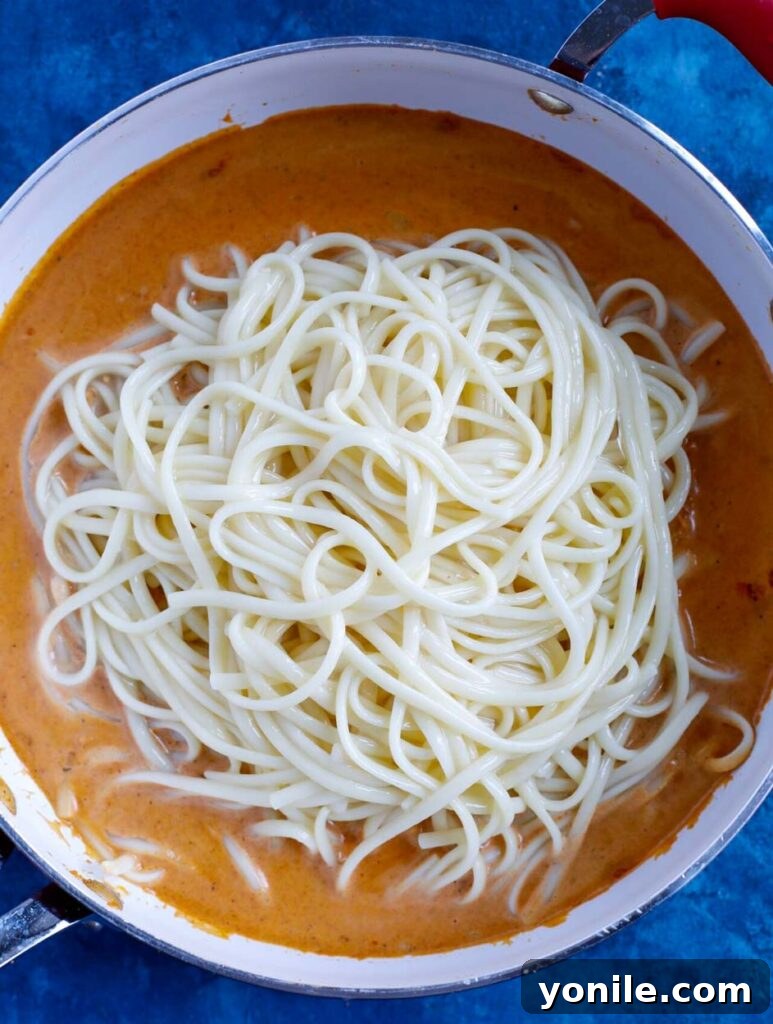 Creamy Cajun Pasta being mixed in a pot.