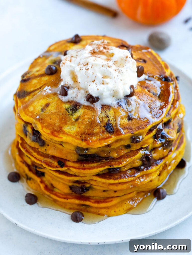 Pumpkin Chocolate Chip Pancakes stack of Pumpkin spice Pancakes with a drizzle of syrup and cream cheese topping
