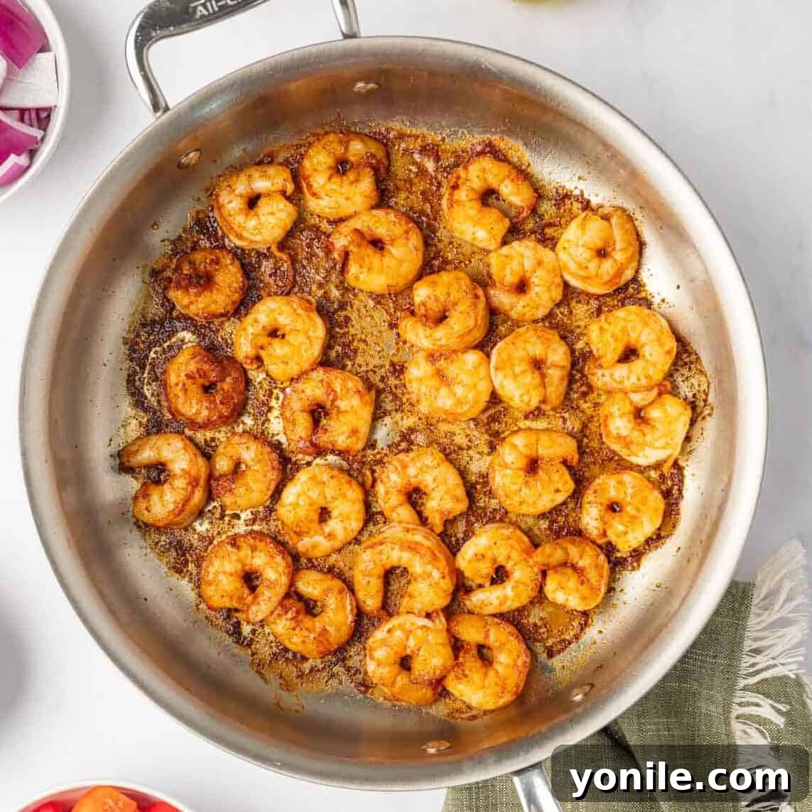Sauteed shrimp in a skillet.