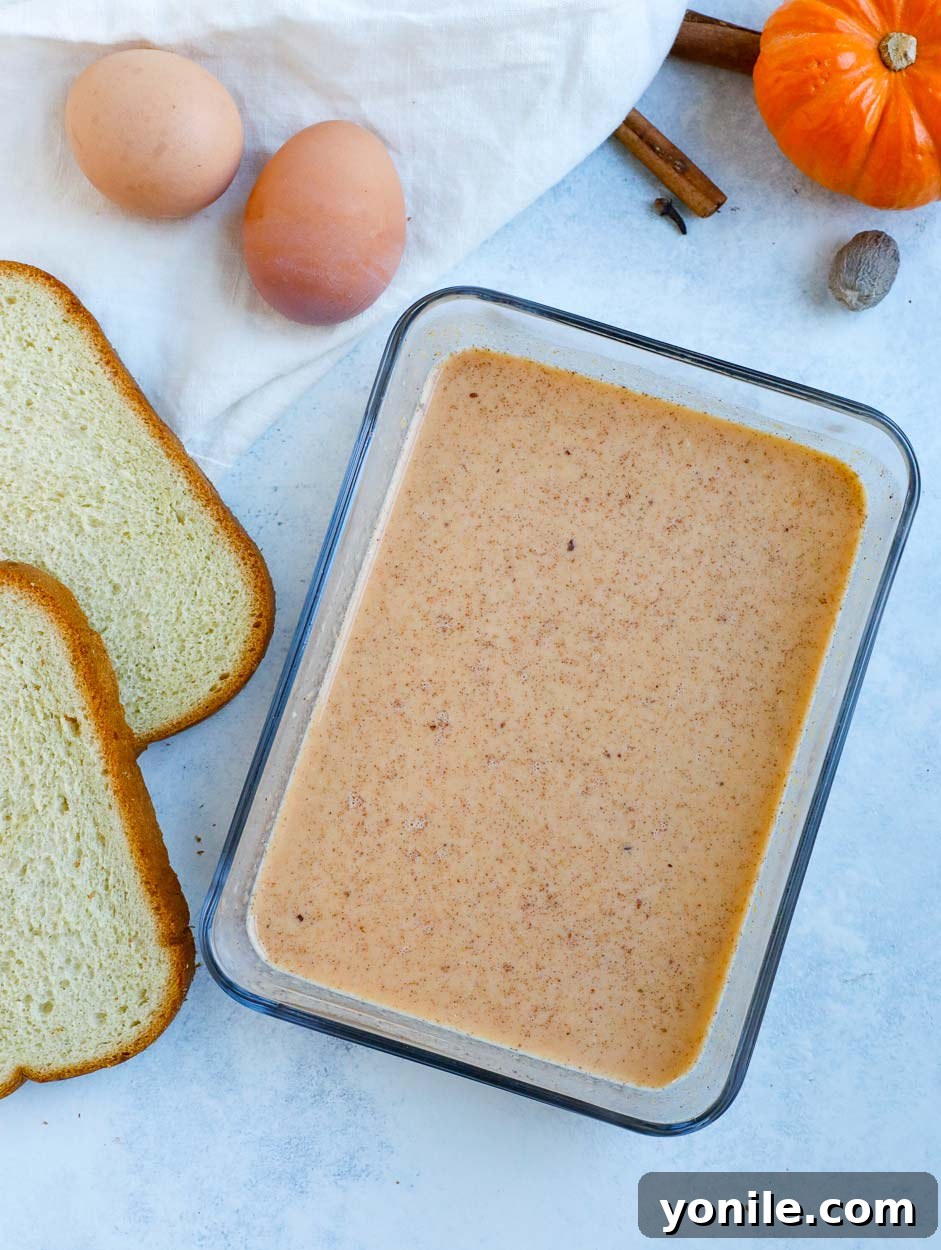 Pumpkin Spice French Toast Batter Close-up of a smooth, creamy pumpkin spice egg mixture in a glass bowl, ready for dipping French toast.