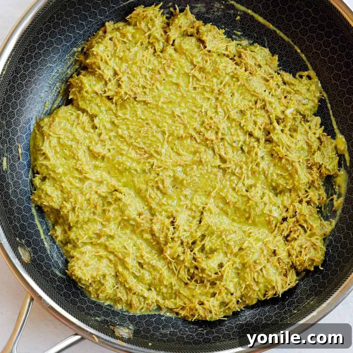 Emirate's Indulgence Bar 6 Pistachio cream kunafa filling evenly mixed in a skillet, showcasing its creamy texture.