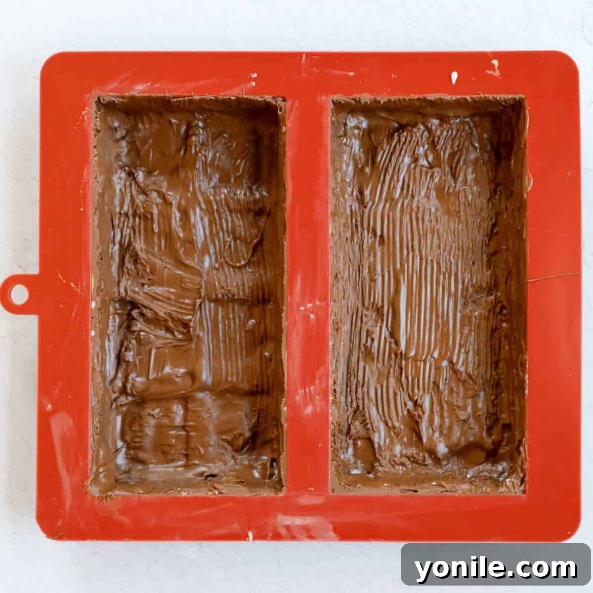 Emirate's Indulgence Bar 8 Process of coating the chocolate mold with melted chocolate to form the sturdy outer shell of the bar.