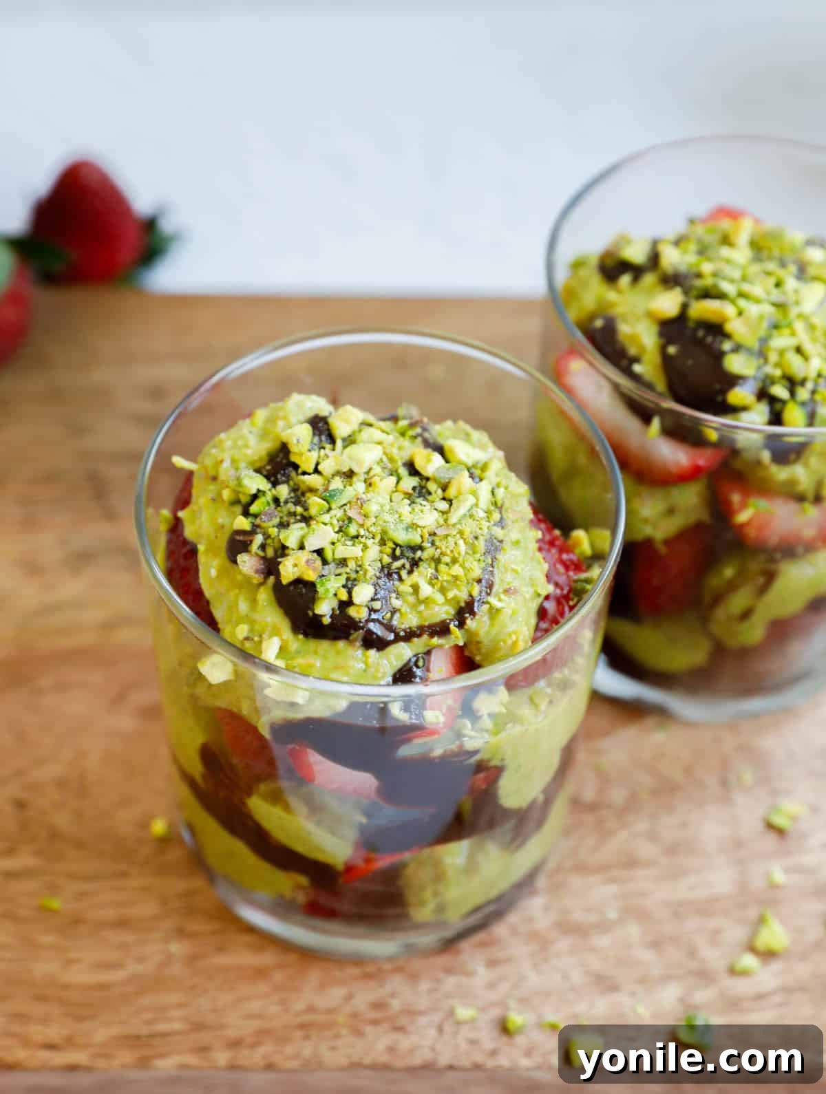 Dubai Strawberry Chocolate Delight 2 Top down shot of luxurious Dubai Strawberry Cups, showcasing layers of golden kataifi, green pistachio cream, rich chocolate, and vibrant red strawberries, ready to be enjoyed.