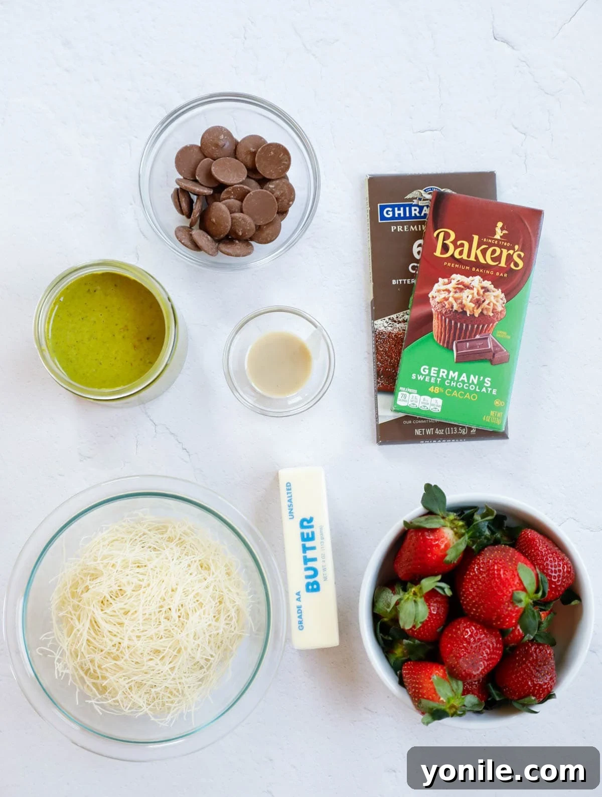 Dubai Strawberry Chocolate Delight 3 Carefully laid out ingredients for making Dubai Strawberry Cups, including fresh strawberries, chocolate, kataifi dough, pistachio cream, butter, and tahini paste.