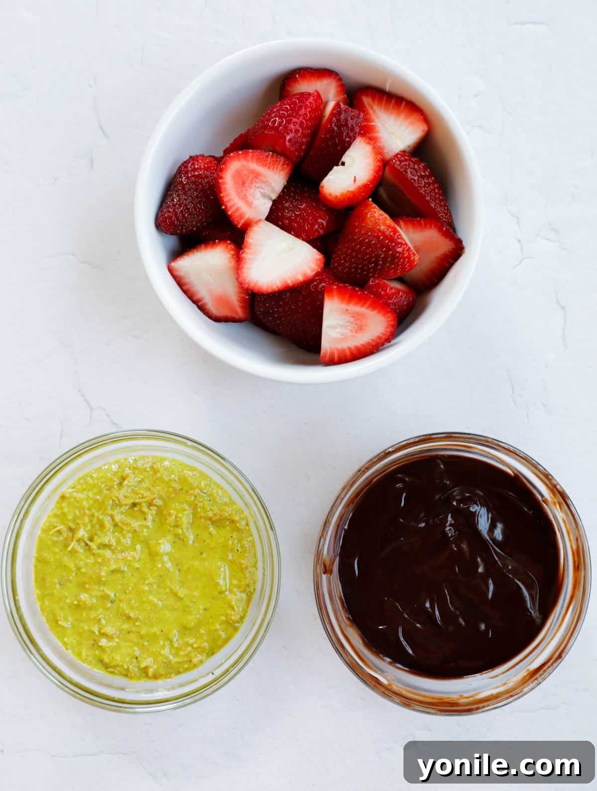 Dubai Strawberry Chocolate Delight 6 Neatly arranged and chopped fresh strawberries, alongside the prepared kataifi-pistachio mixture and chocolate ganache, awaiting assembly into Dubai Strawberry Cups.