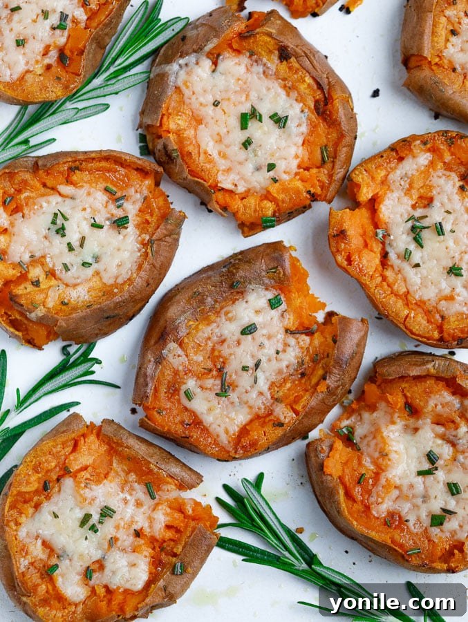 Crispy Smashed Sweet Potatoes with Herbs and Garlic Top-down shot of crispy Smashed Sweet Potatoes with fresh herbs and garlic, garnished with Parmesan cheese, ready to serve.