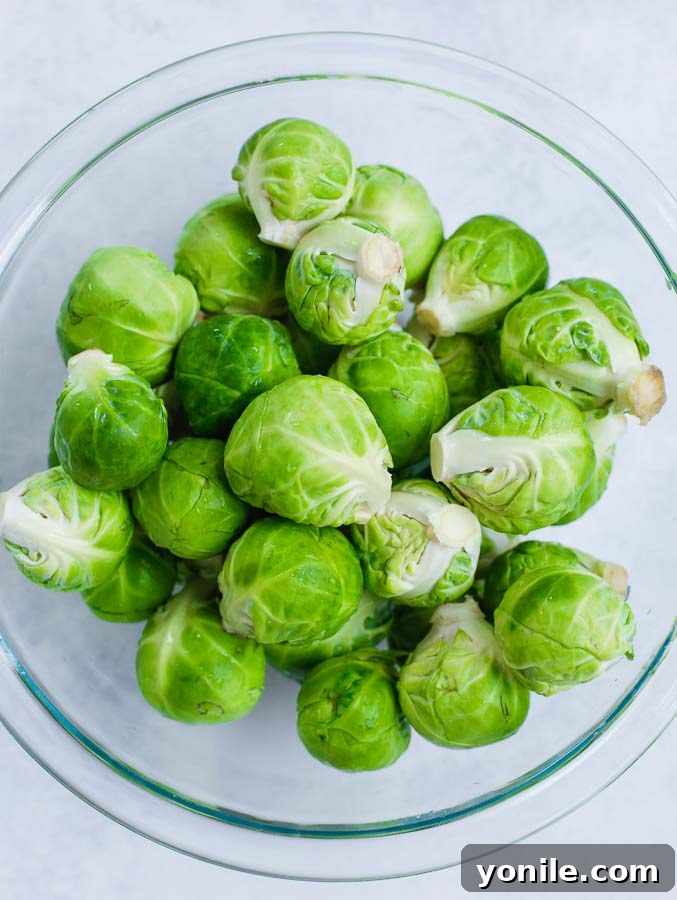Cleaned and halved Brussels sprouts in a glass bowl