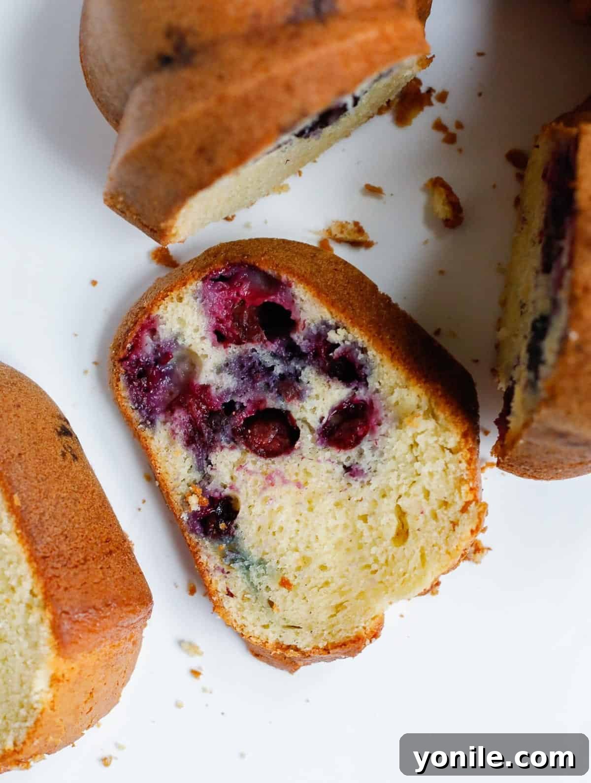 Luscious Blueberry Bundt Cake 7 A whole blueberry Bundt cake displayed alongside a single perfect slice, showcasing its beauty and deliciousness.