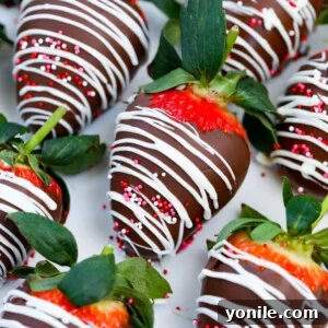 Rows of Easy Chocolate Covered Strawberries, garnished with white chocolate drizzles and colorful sprinkles.