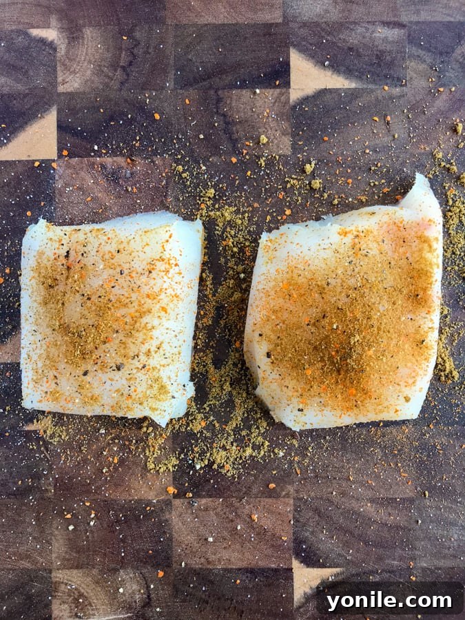 Marinated mahi mahi fillets on a wooden counter.