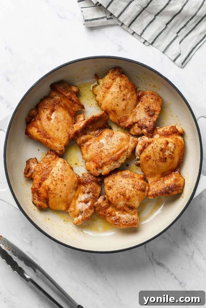 Velvety Sun-Dried Tomato Chicken Thighs 3 Pan seared chicken thighs with a golden crust in a skillet.