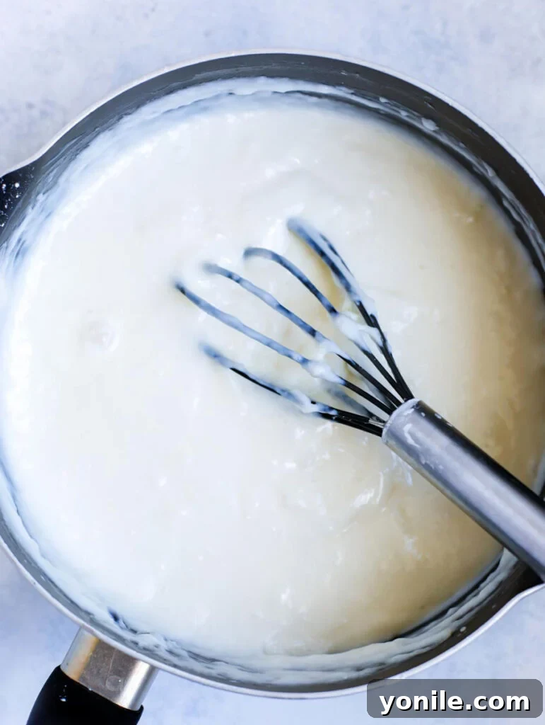 Flaky Lebanese Shaabiyat Pastry 5 ashta filling in a pot with a whisk