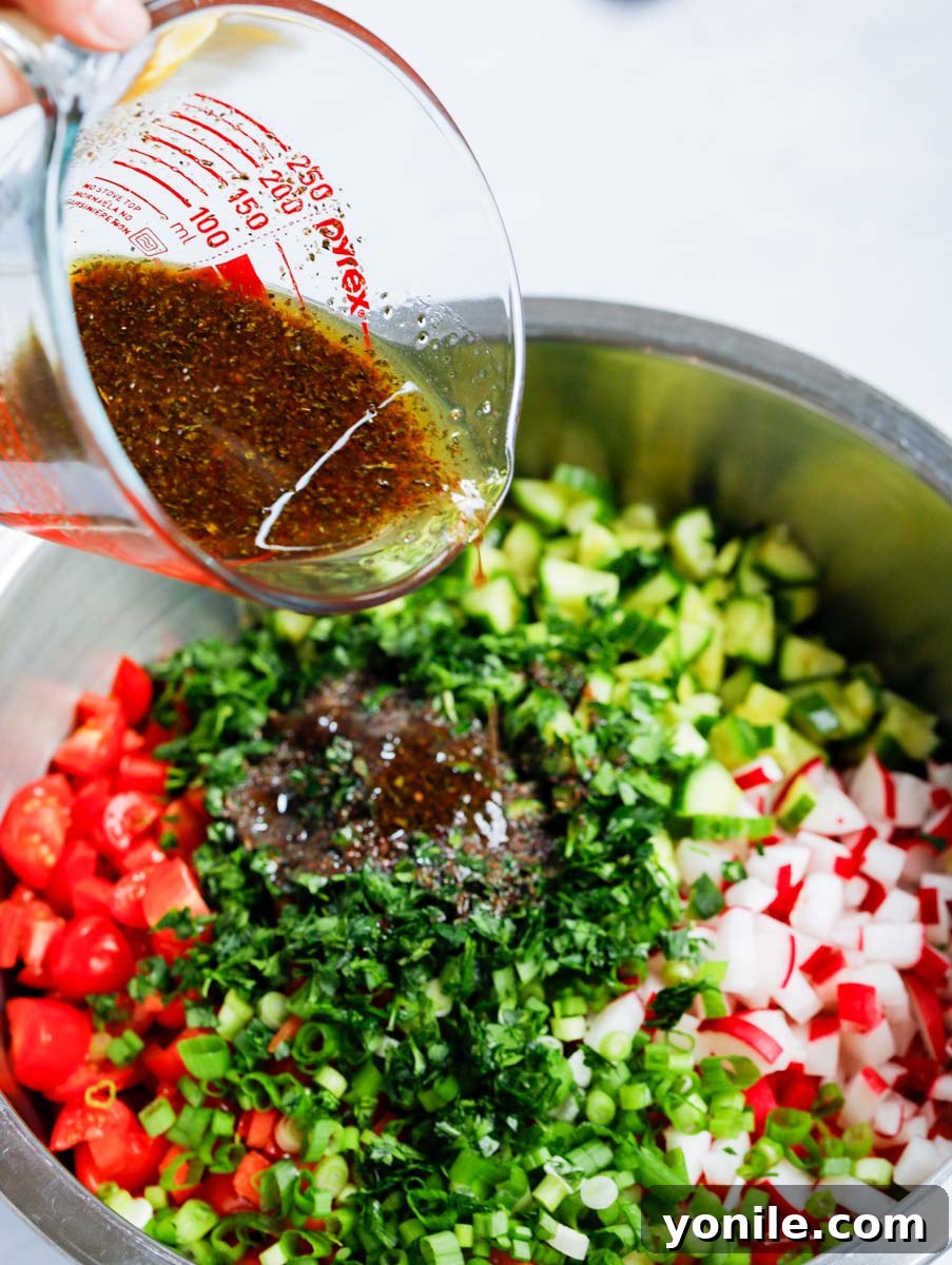 Dressing being poured over the cabbage fattoush salad