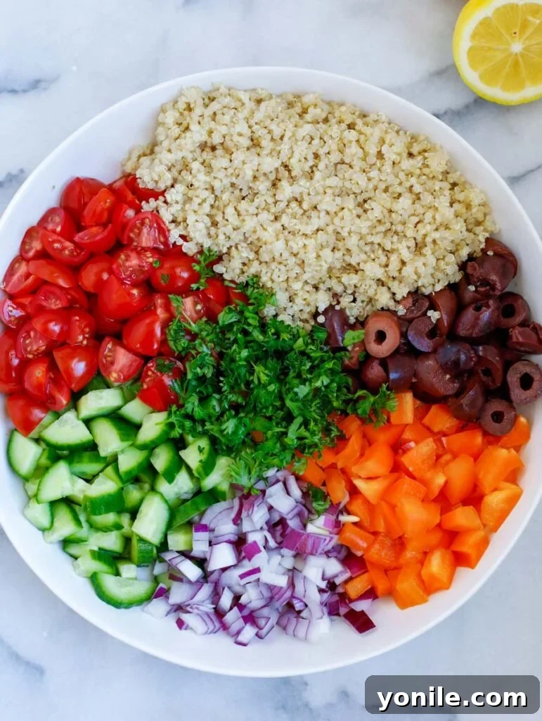 various fresh ingredients for Mediterranean quinoa salad chopped and arranged on a white plate