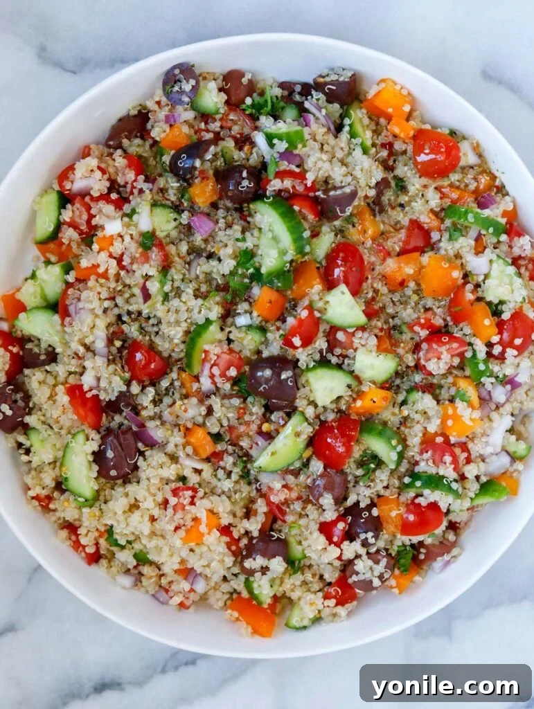 top-down view of the Mediterranean quinoa salad after the dressing has been added, showing a vibrant mix of colors