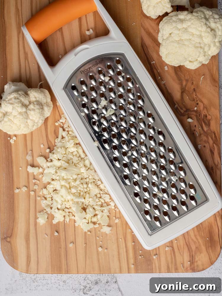 A bowl filled with finely grated cauliflower, ready for cooking