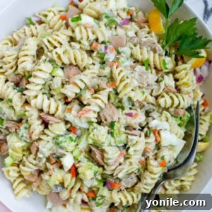 A serving of Tuna Pasta Salad in a bowl with a fork, emphasizing its delicious appeal.