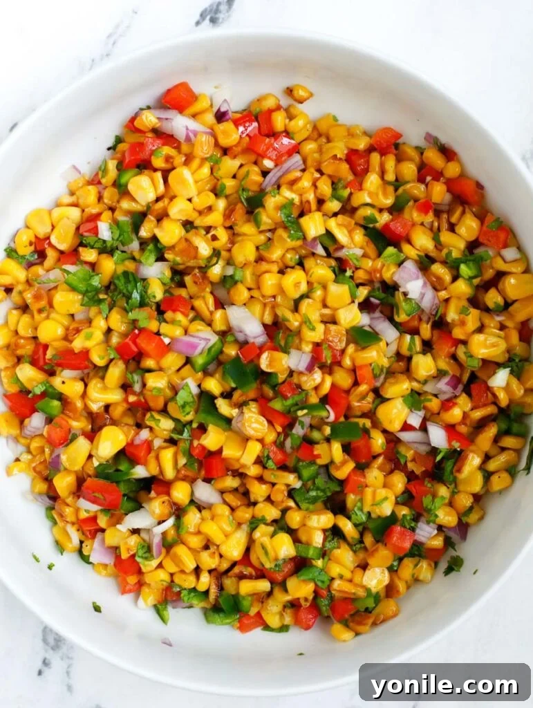 Overhead shot of the assembled Mexican street corn salad in a large bowl, before final garnishing.