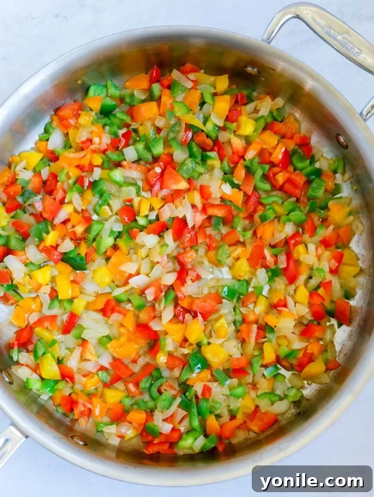 Sizzling Fajita Macaroni 5 Cooking diced bell peppers and onions in a pan