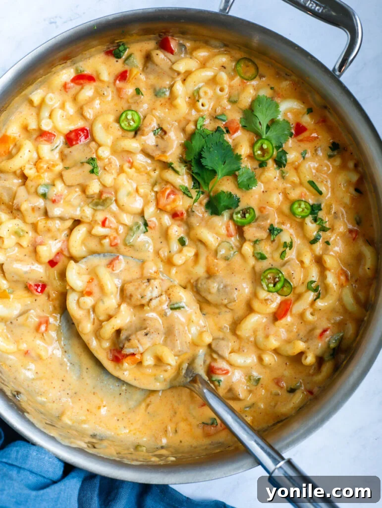 Sizzling Fajita Macaroni 9 Spoon digging into a pot of creamy chicken mac and cheese