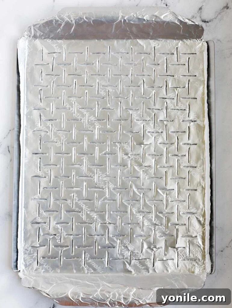 Grilled Garden Goodness 4 Grilling tray meticulously lined with Reynolds Non-Stick Foil, with incisions made over the holes