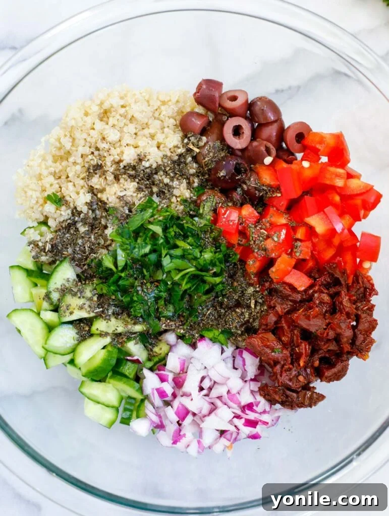 Vibrant Mediterranean Quinoa Salad 3 Various ingredients for Easy Mediterranean Quinoa Salad recipe laid out on a board, including chopped vegetables, olives, and mozzarella.