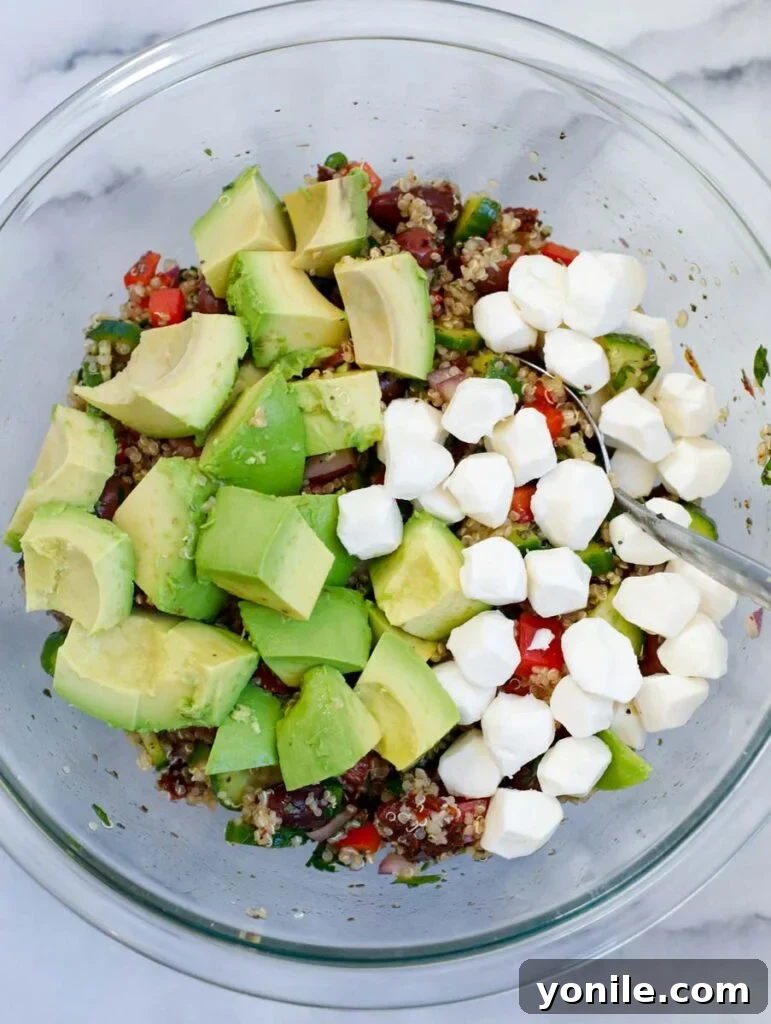 Vibrant Mediterranean Quinoa Salad 4 Diced avocado and small mozzarella balls in a bowl, ready to be added to the salad.