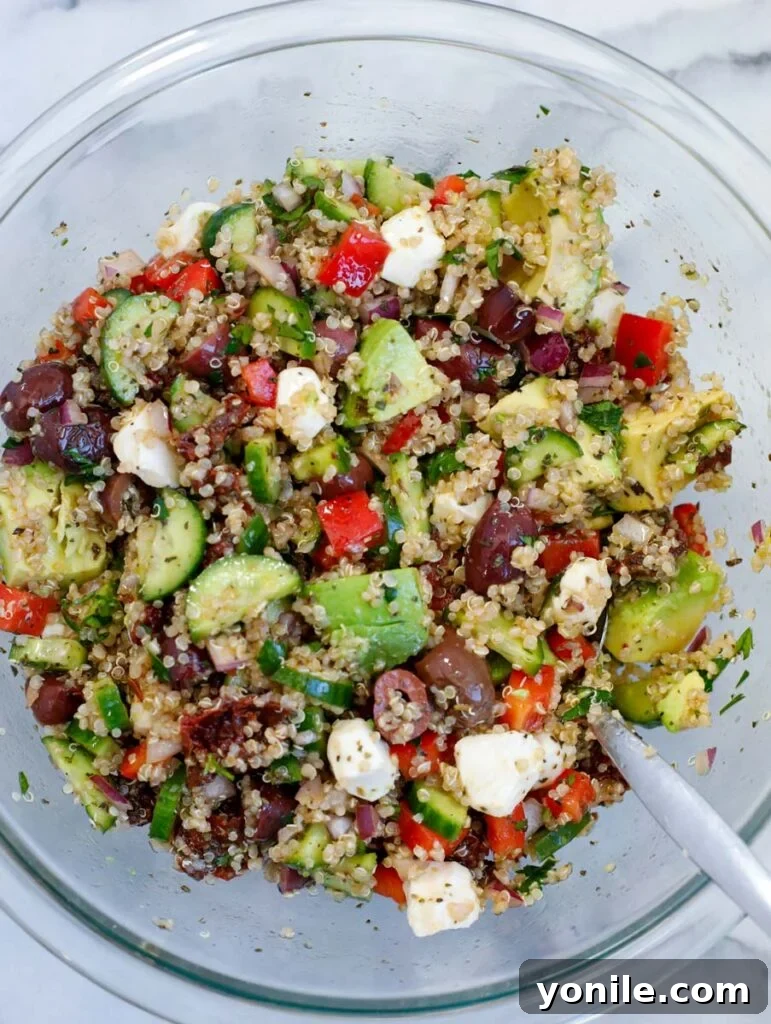 Vibrant Mediterranean Quinoa Salad 5 Top down shot of Easy Mediterranean Quinoa Salad in a serving bowl, garnished with fresh herbs.