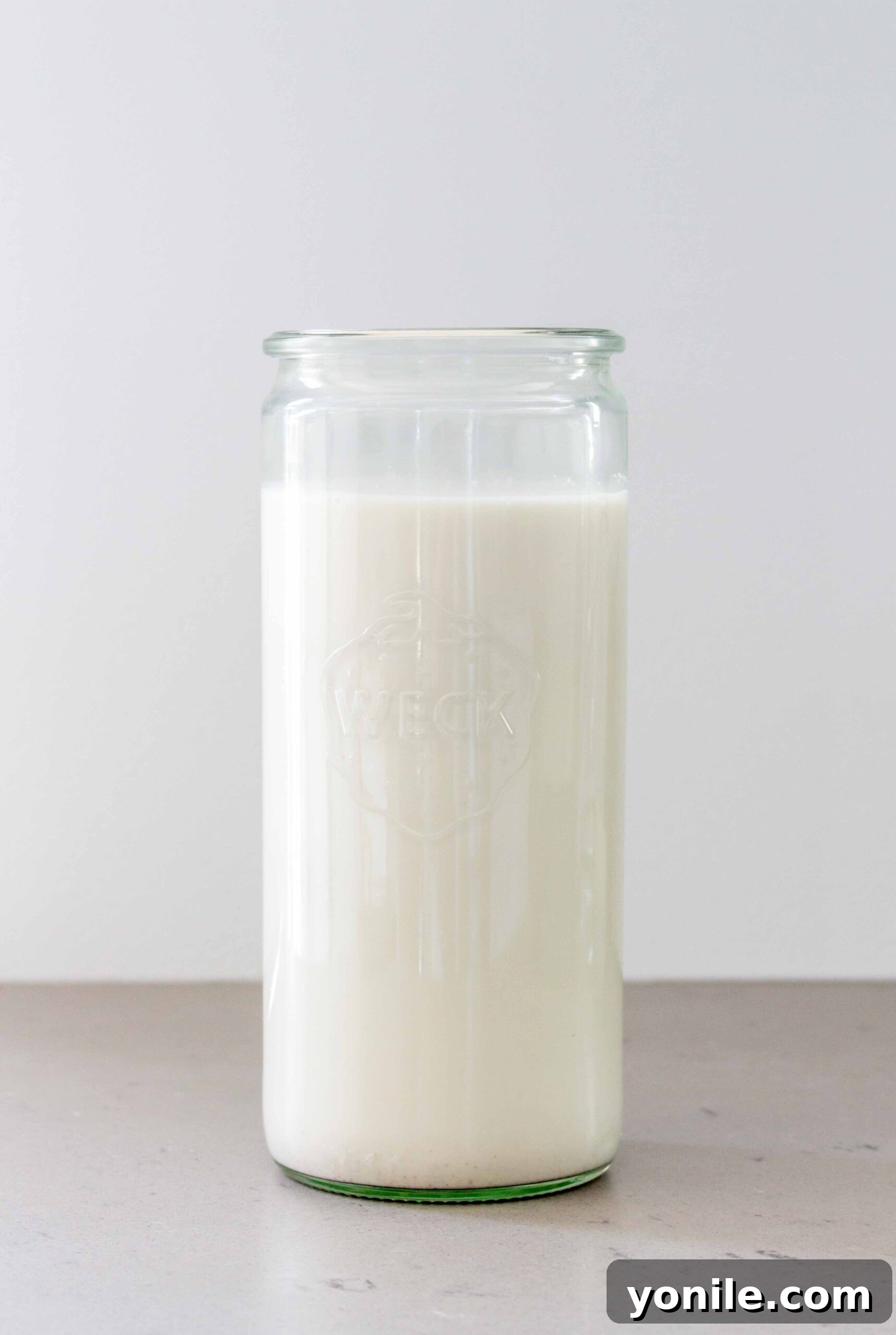 glass bottle of almond milk on a wooden surface