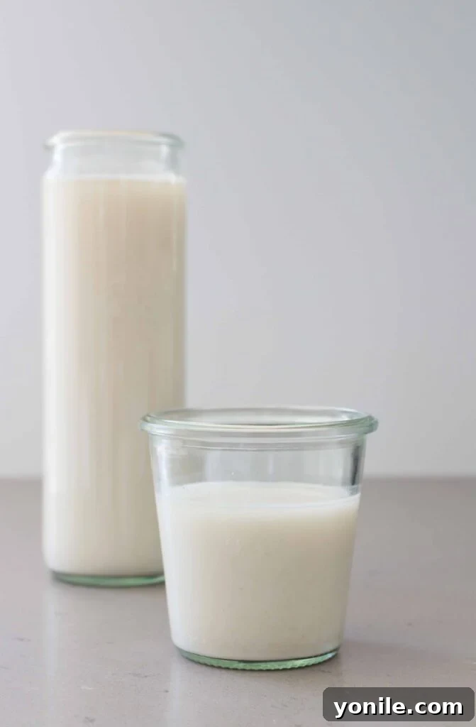 Freshly poured homemade oat milk in a glass cup, ready to be enjoyed