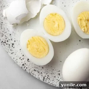 A hard boiled egg sliced in the middle showing a vibrant, creamy yolk.