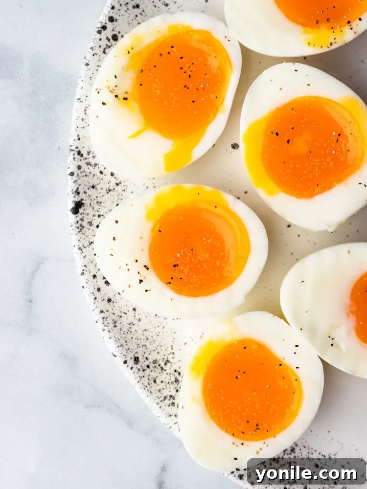 Mastering the Soft Boiled Egg 2 Two soft-boiled eggs, cut in half, revealing their perfectly runny, golden yolks and firm whites, ready to be enjoyed.